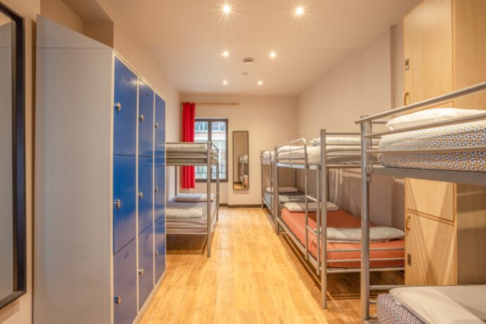 Un cómodo dormitorio de 8 camas con taquillas en un albergue de Niza, Francia