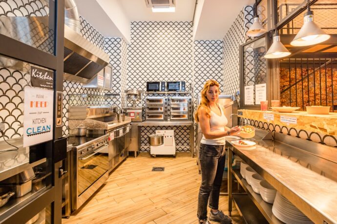 Pessoas a cozinhar numa moderna cozinha comum de um hostel em Nice, França