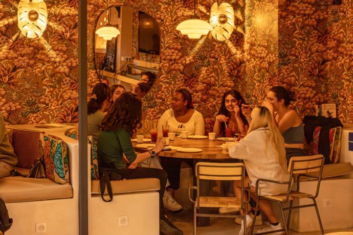 Eine Gruppe von Freunden hat Spaß in einer Café-Bar im Hostel in Nizza, Frankreich.