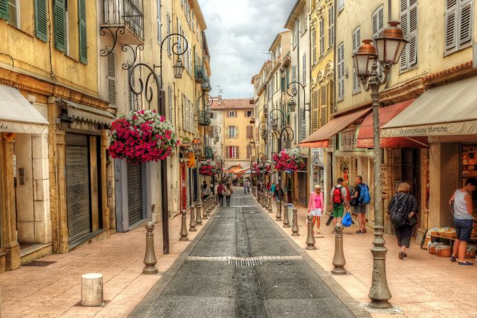 Jolie rue de la vieille ville avec des bâtiments jaunes colorés et des fleurs roses