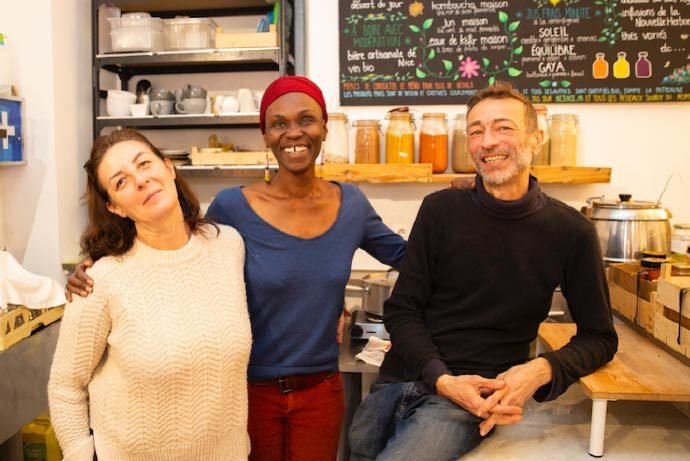 Trois personnes souriant dans un café Nice France, superbes endroits pour les brunchs.