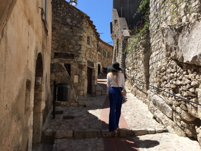 A girl walking up an old town stone street in Eze village in the South of France