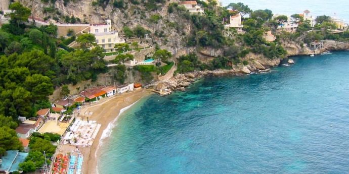 Uma bela praia na Riviera Francesa, com água azul-turquesa e areia dourada